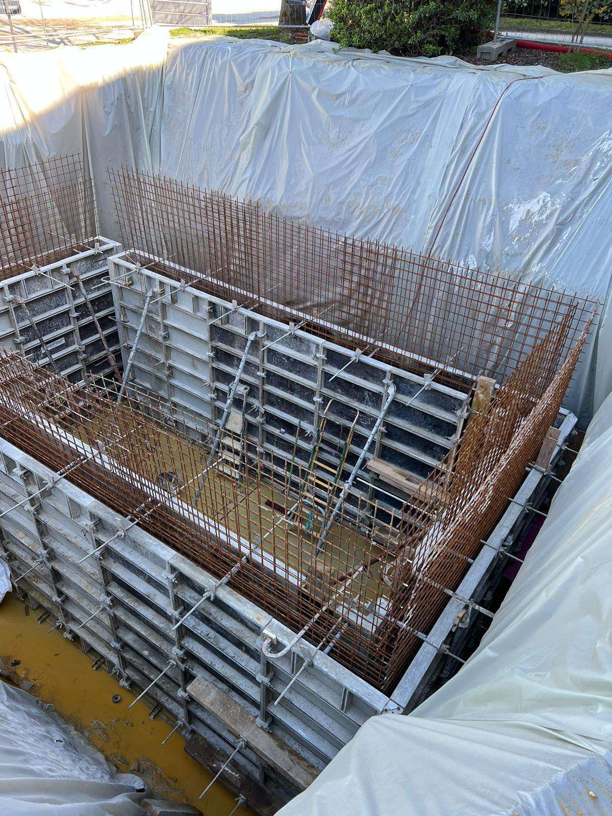 Coffrages et armatures de voiles en béton dans une fouille