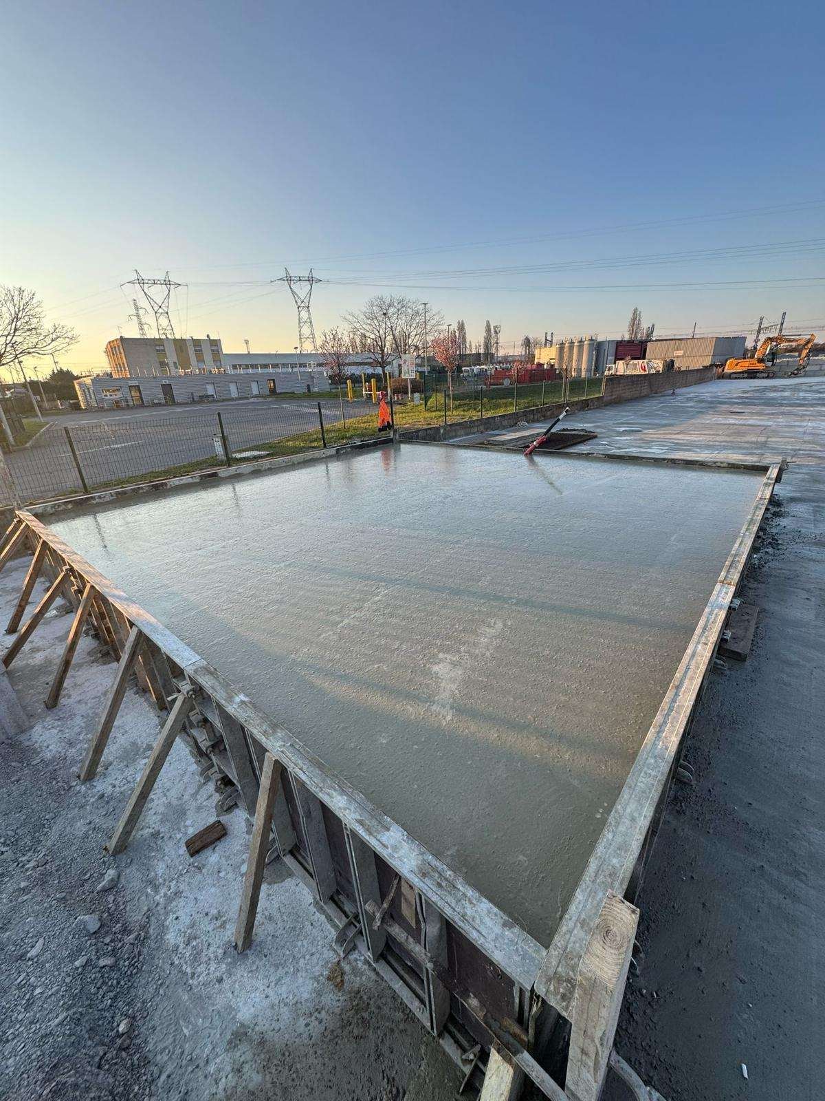 Dalle béton fraîchement coulée dans son coffrage bois